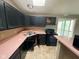 Traditional kitchen with black appliances and cabinets with pink countertops at 11106 Wismar Dr, Indianapolis, IN 46235