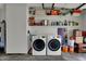 Clean, organized garage space with washer, dryer, water heater, and shelving for ample storage at 1111 Cambridge Dr, Greenwood, IN 46142