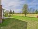Large backyard with a well-kept lawn, patio area with an outdoor table, and a newly installed wooden fence at 11840 Geyser Ct, Fishers, IN 46038