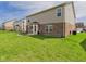 A well-maintained backyard with green grass, a patio, and an area for outdoor entertaining, with a clear sky above at 11840 Geyser Ct, Fishers, IN 46038