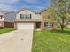 Charming two-story home boasts a brick and tan siding exterior with an attached two-car garage at 11840 Geyser Ct, Fishers, IN 46038
