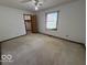Bedroom with tan carpet, a window with blinds, and a standard closet with a wood door at 1215 Willow Springs Blvd, Brownsburg, IN 46112