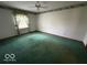 Spacious bedroom with soft green carpet, a ceiling fan, and large window with natural light at 1215 Willow Springs Blvd, Brownsburg, IN 46112