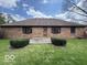 Back exterior view of brick home with lawn, showing back door and AC unit at 1215 Willow Springs Blvd, Brownsburg, IN 46112