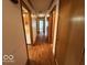 Long hallway boasts beautiful wood flooring and neutral walls, leading to various rooms at 1215 Willow Springs Blvd, Brownsburg, IN 46112