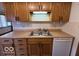 Close up view of the light wood cabinets and laminate countertop with stainless steel sink at 1215 Willow Springs Blvd, Brownsburg, IN 46112