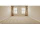 Neutral bedroom with carpet, two large windows, and decorative curtains at 12561 Gladecrest Dr, Carmel, IN 46033