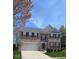 Charming brick two-story home with a two car garage, manicured lawn, and dark shutters at 12561 Gladecrest Dr, Carmel, IN 46033