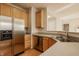 Stainless steel refrigerator and dishwasher in kitchen with light wood cabinets and countertops at 12561 Gladecrest Dr, Carmel, IN 46033
