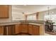Modern kitchen with a stainless steel dishwasher and sink with gray countertops and wood cabinets at 12561 Gladecrest Dr, Carmel, IN 46033