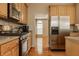 Stainless steel appliances and wooden cabinets in kitchen, and hardwood floors at 12561 Gladecrest Dr, Carmel, IN 46033