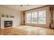 Bright living room featuring a fireplace, hardwood floors, and large windows at 12561 Gladecrest Dr, Carmel, IN 46033