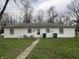 The rear of a classic home is enhanced by a green lawn and convenient access to outdoor utilities at 129 S Boehning St, Indianapolis, IN 46219