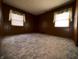 Spacious bedroom featuring wood paneling and two windows dressed with decorative valances, offering natural light at 129 S Boehning St, Indianapolis, IN 46219