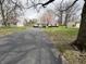 Charming single-story home with a long driveway, lush lawn, and mature trees at 129 S Boehning St, Indianapolis, IN 46219