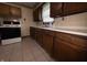 Kitchen with white appliances, tile flooring, and wood cabinets, providing ample storage and functionality at 129 S Boehning St, Indianapolis, IN 46219