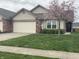 Charming single-story home featuring an attached garage, beautiful lawn, and blossoming tree at 1302 Lexington Trl, Greenfield, IN 46140