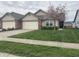 Charming single-story home featuring an attached garage, beautiful lawn, and blossoming tree at 1302 Lexington Trl, Greenfield, IN 46140