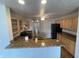 Open-concept kitchen with breakfast bar, granite counters, wood cabinets, and modern appliances at 1302 Lexington Trl, Greenfield, IN 46140