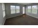 Bright room featuring neutral paint and multiple windows overlooking the fenced yard at 1302 Lexington Trl, Greenfield, IN 46140
