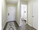 Bright entryway with a stylish rug, white doors, and a glimpse into a half bathroom, leading to the home's interior at 1328 Osprey Way, Greenwood, IN 46143