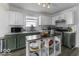 An open concept kitchen with white cabinets, stainless appliances, and a dark wood center island at 1328 Osprey Way, Greenwood, IN 46143