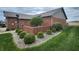 Well landscaped lawn featuring a low brick enclosure with small trees and bushes at 1330 Country Creek Cir, Shelbyville, IN 46176