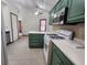 Well-lit kitchen with stainless microwave, white range, and green cabinets and island at 1330 Country Creek Cir, Shelbyville, IN 46176