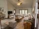 Staged living room with neutral furniture, ceiling fan, and backyard view at 1330 Country Creek Cir, Shelbyville, IN 46176