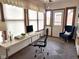 A comfortable office with a work space, a blue chair, and natural light from several windows at 1330 Country Creek Cir, Shelbyville, IN 46176