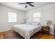 Bright bedroom with a ceiling fan, two windows, and hardwood floors under a decorative rug at 1355 E 56Th St, Indianapolis, IN 46220