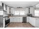 Modern kitchen with stainless steel appliances, white cabinets, and tiled backsplash at 1355 E 56Th St, Indianapolis, IN 46220