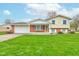 Charming two-story home with a well-manicured lawn and a brick and siding exterior under a bright blue sky at 1503 Saint John S Ct, Beech Grove, IN 46107