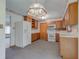 Traditional kitchen featuring wood cabinets, white appliances, and a unique ceiling light fixture at 1503 Saint John S Ct, Beech Grove, IN 46107