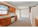Bright kitchen with wood cabinets, dishwasher, and a view to the backyard through a window at 1503 Saint John S Ct, Beech Grove, IN 46107