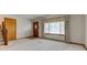Welcoming living room featuring soft carpet, a large window, and a traditional wooden door and staircase at 1503 Saint John S Ct, Beech Grove, IN 46107