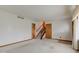 Spacious living room with neutral carpeting, a staircase, and a view into another room, offering potential at 1503 Saint John S Ct, Beech Grove, IN 46107