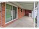 Covered patio with sliding glass door and brick accent offers a perfect spot for outdoor relaxation at 1503 Saint John S Ct, Beech Grove, IN 46107
