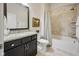 Bathroom vanity with granite counters, dark cabinets, framed mirror and shower/tub combo at 15150 Mooring E Cir, Carmel, IN 46033
