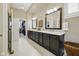 Bathroom featuring long vanity with dual sinks, framed mirrors, and a walk-in closet at 15150 Mooring E Cir, Carmel, IN 46033
