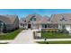 Charming home exterior showcasing manicured landscaping, flowers, a white picket fence and a well-maintained lawn at 15150 Mooring E Cir, Carmel, IN 46033