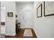 Hallway with hardwood floors, white walls, console table, and view into a bedroom at 15150 Mooring E Cir, Carmel, IN 46033