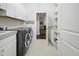 Clean laundry room with cabinets, counters, a sink, and modern appliances at 15150 Mooring E Cir, Carmel, IN 46033