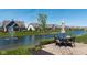 Outdoor patio with table and chairs overlooking a pond and manicured lawn at 15150 Mooring E Cir, Carmel, IN 46033