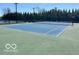 Beautiful tennis court with blue surface and surrounding green landscape, perfect for outdoor recreation at 15150 Mooring E Cir, Carmel, IN 46033