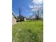 Large green backyard with potential for outdoor activities, surrounded by neighboring homes and mature trees at 1710 Stevenson St, Indianapolis, IN 46228