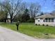Front yard view showcasing the home's exterior, green lawn and the surrounding trees at 1710 Stevenson St, Indianapolis, IN 46228