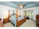 The main bedroom is spacious, with a four-poster bed, blue accent walls, and natural light from the windows at 1770 Valleywood Dr, Avon, IN 46123