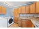 Kitchen area featuring wooden cabinets, countertops, appliances, and a laundry area at 1857 Calvin St, Indianapolis, IN 46203
