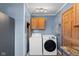 Functional laundry area with modern washer and dryer, overhead storage, and utility connections at 1857 Calvin St, Indianapolis, IN 46203